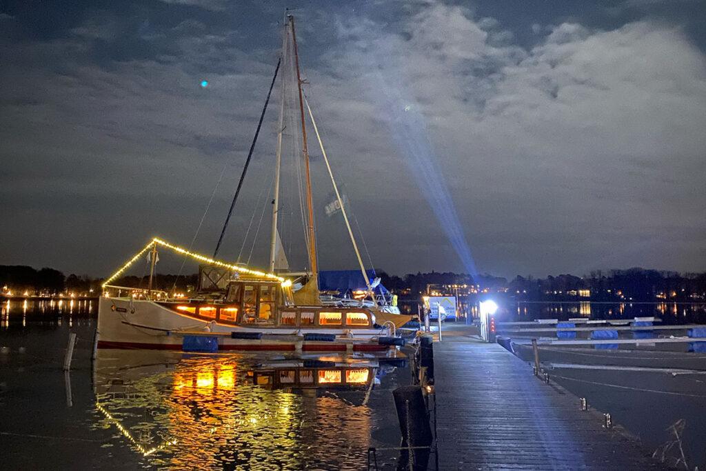 Nachts am Scharmützelsee stehen wundervoll beleuchtete Boote im Hafen