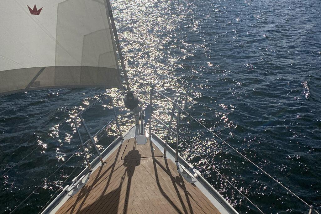 Bug einer Segelyacht mit Blick nach vorn. Glitzerndes Wasser.